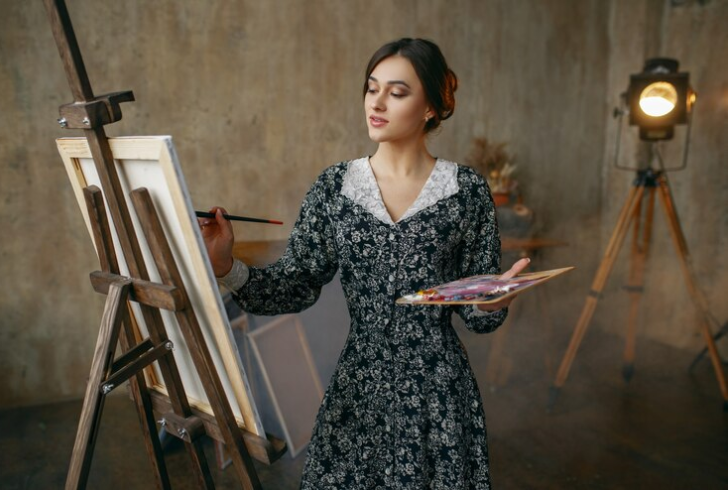 Woman painting on canvas at home